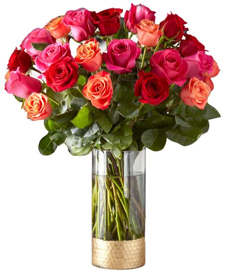 Assorted roses arranged in a vase with baby's breath and greenery.